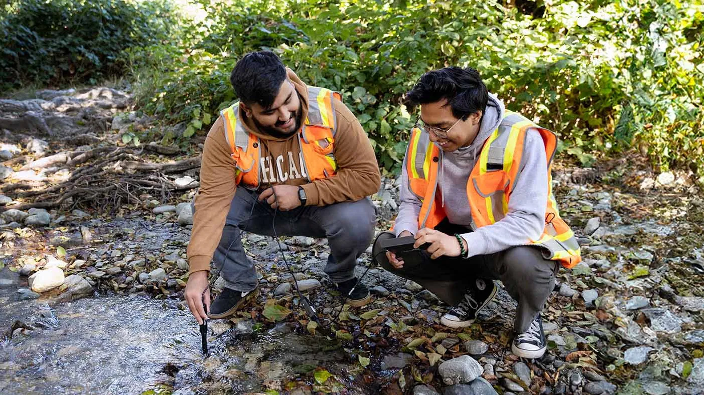 CSUSB students Alan Salcedo (left) and David Hernandez check water readings at Lytle Creek for their Geography Field Experience class. 